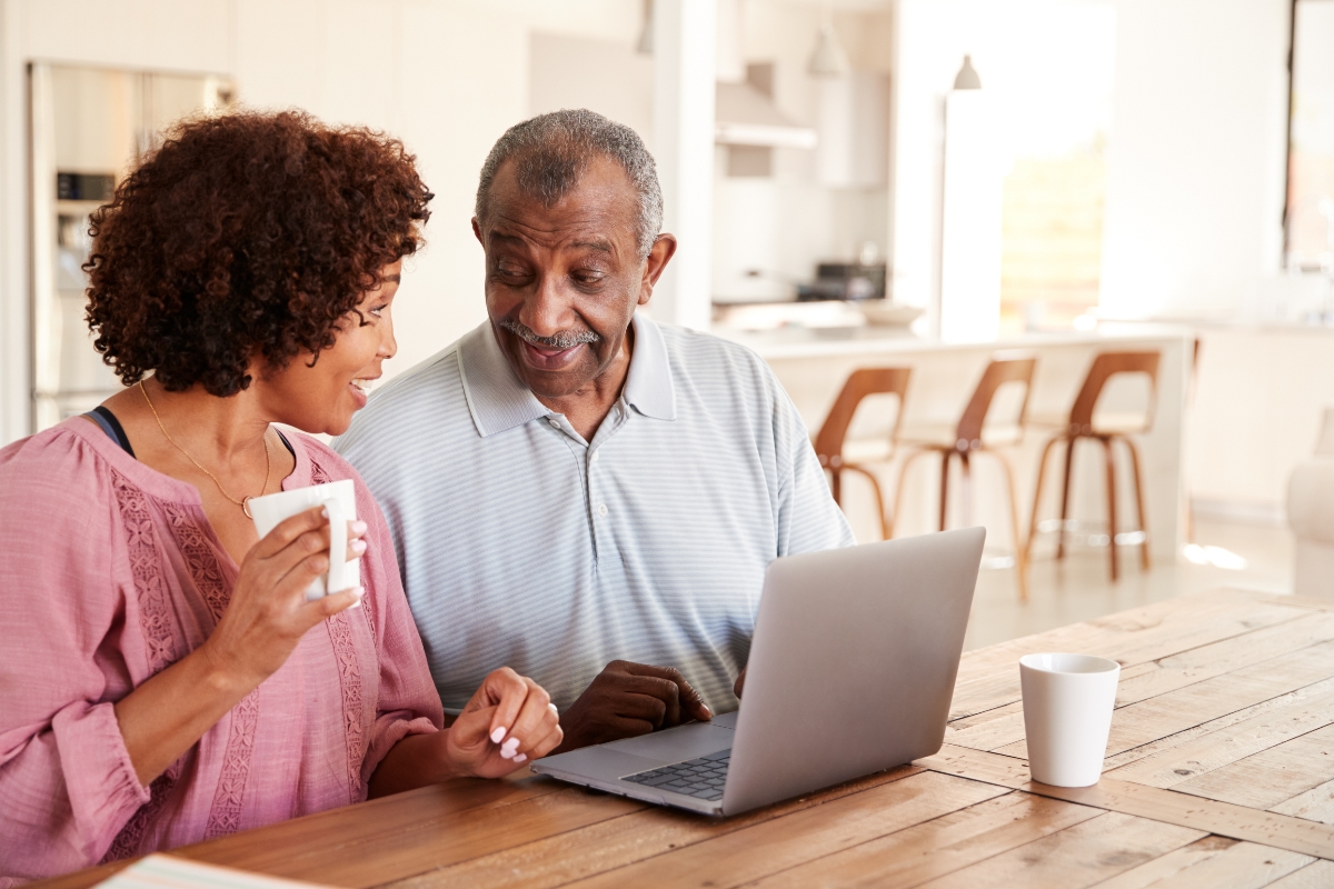 Black father and daughter looking at computer